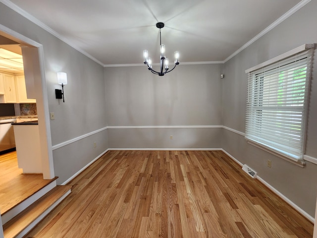 unfurnished dining area featuring an inviting chandelier, ornamental molding, and light wood-type flooring