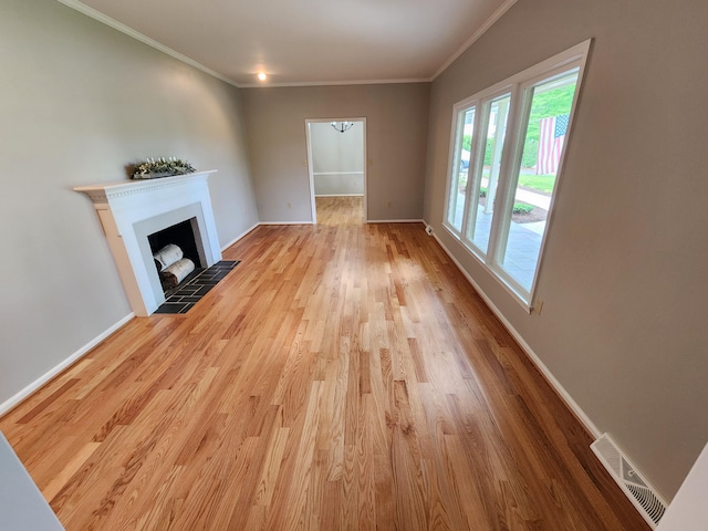 unfurnished living room with ornamental molding, a fireplace, and light hardwood / wood-style flooring