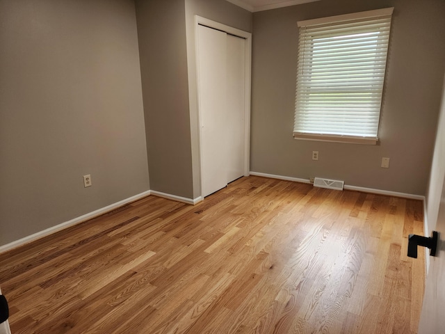 unfurnished bedroom with light hardwood / wood-style flooring and a closet