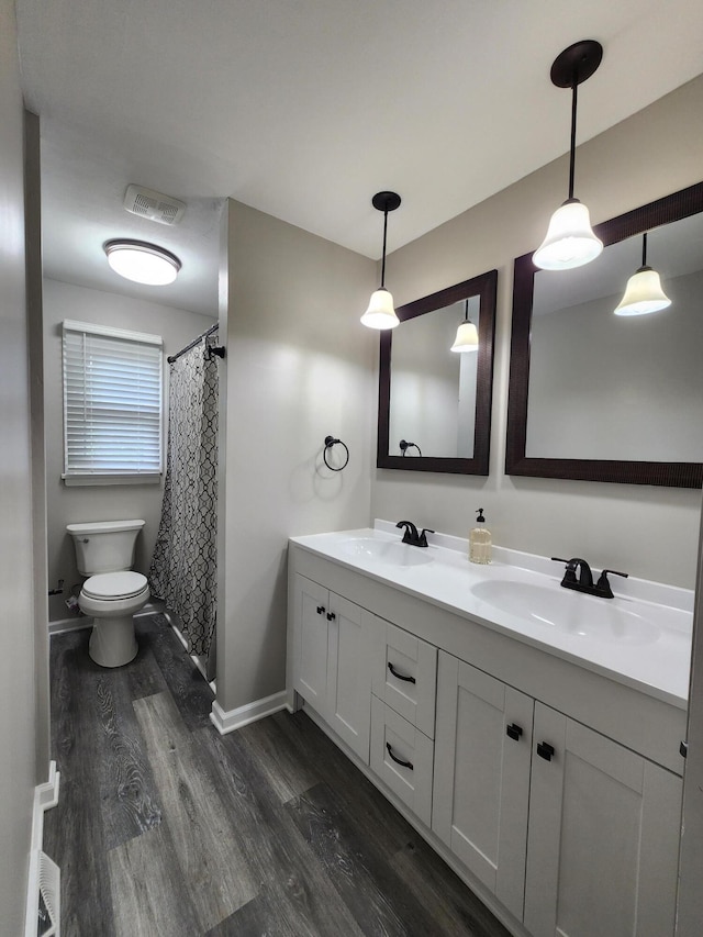 bathroom with hardwood / wood-style floors, vanity, and toilet