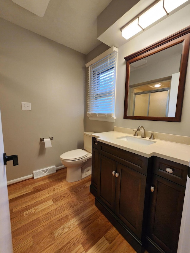 bathroom with hardwood / wood-style floors, vanity, and toilet