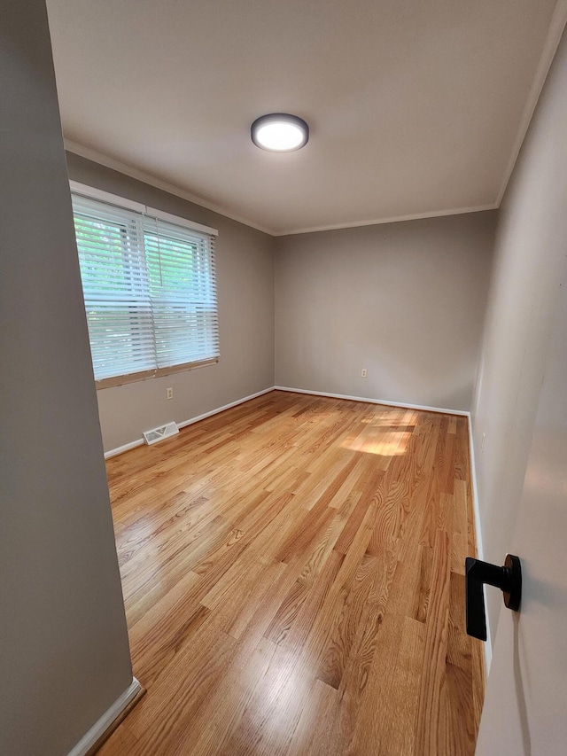 spare room with light hardwood / wood-style floors and ornamental molding