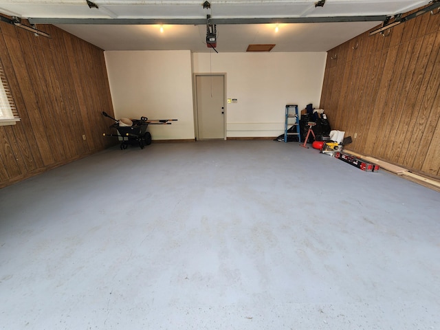 garage with wood walls and a garage door opener