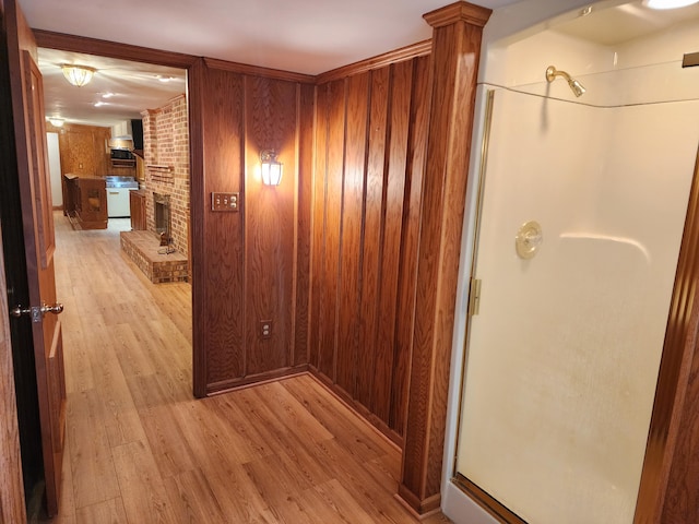 hallway featuring wooden walls and light hardwood / wood-style flooring