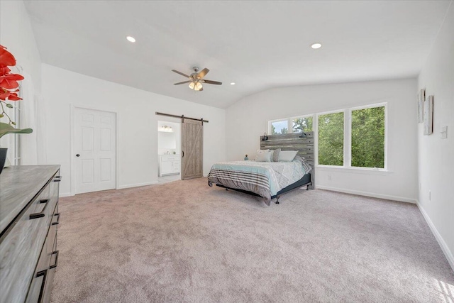 carpeted bedroom with a barn door, ceiling fan, and vaulted ceiling