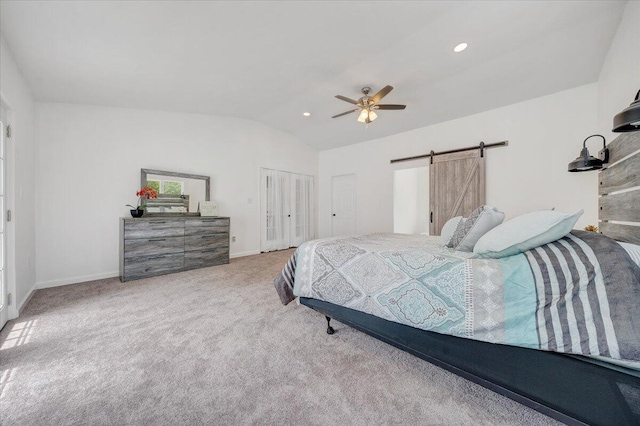 bedroom featuring a barn door, carpet, ceiling fan, and vaulted ceiling