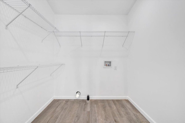 clothes washing area featuring hardwood / wood-style floors and washer hookup