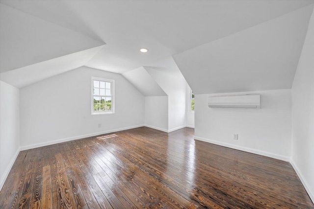 bonus room with dark hardwood / wood-style flooring, vaulted ceiling, and an AC wall unit