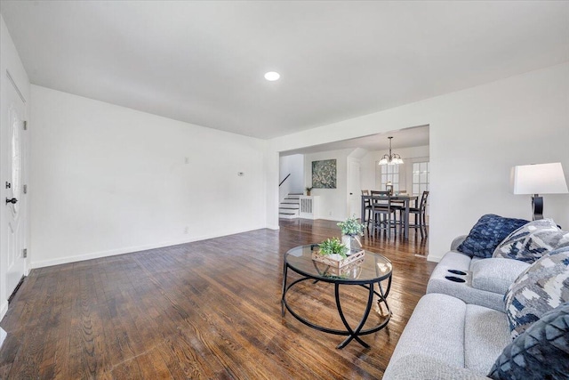 living room with a chandelier and dark wood-type flooring