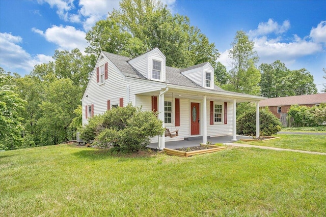 new england style home with a front yard and covered porch