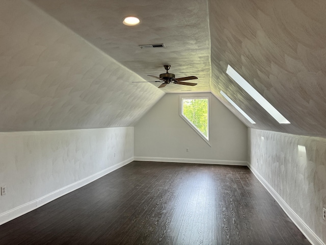 bonus room with hardwood / wood-style floors, ceiling fan, and lofted ceiling with skylight