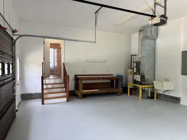 garage featuring sink, a garage door opener, and electric water heater