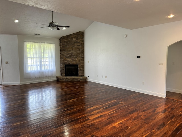 unfurnished living room with vaulted ceiling, a textured ceiling, dark hardwood / wood-style floors, and a fireplace