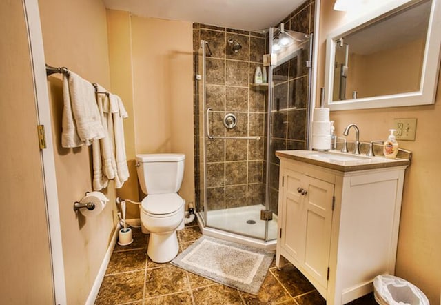 bathroom featuring tile floors, a shower with door, vanity, and toilet