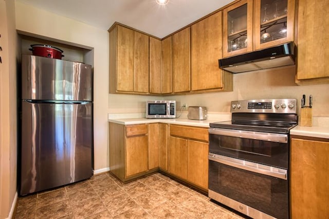 kitchen featuring light tile flooring and appliances with stainless steel finishes