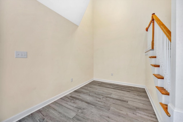 interior space with hardwood / wood-style flooring and vaulted ceiling