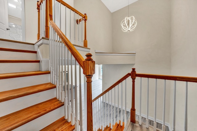 stairway featuring hardwood / wood-style floors and an inviting chandelier