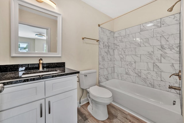 full bathroom with toilet, vanity, wood-type flooring, and tiled shower / bath