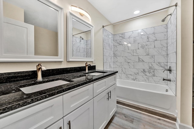 bathroom with hardwood / wood-style floors, vanity, and tiled shower / bath combo