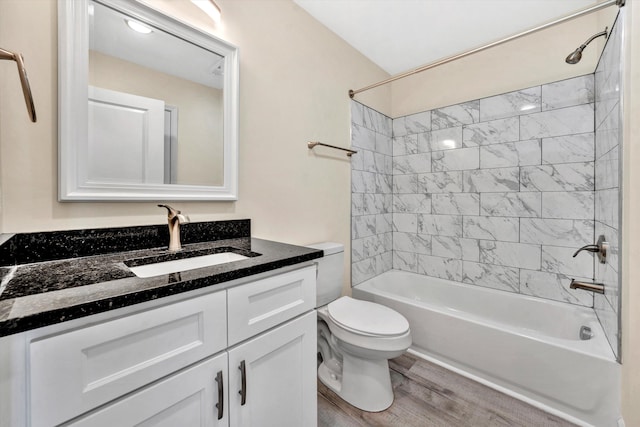 full bathroom with vanity, hardwood / wood-style floors, tiled shower / bath combo, and toilet