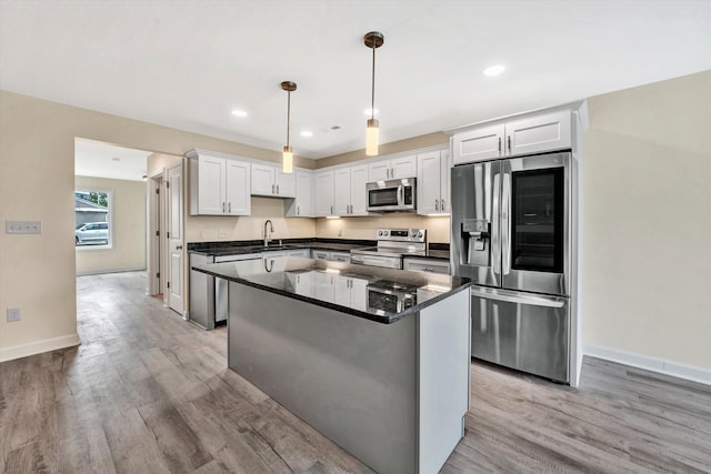 kitchen with white cabinets, pendant lighting, sink, and stainless steel appliances