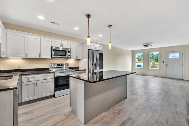 kitchen featuring white cabinetry, a kitchen island, pendant lighting, and appliances with stainless steel finishes