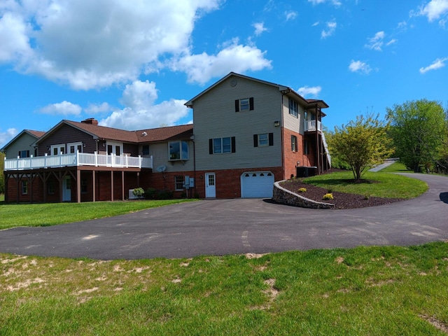 view of front of home with a front yard, a garage, and a balcony