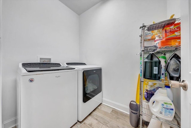 laundry room featuring hookup for a washing machine, washer and dryer, and light hardwood / wood-style floors