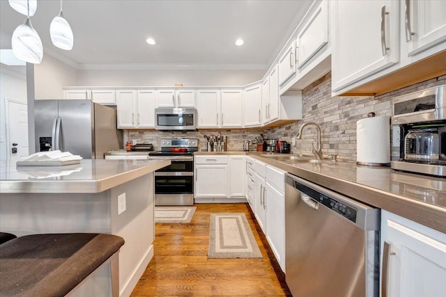 kitchen with backsplash, appliances with stainless steel finishes, sink, and light wood-type flooring