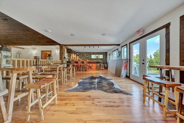 dining space with light hardwood / wood-style floors, french doors, and track lighting