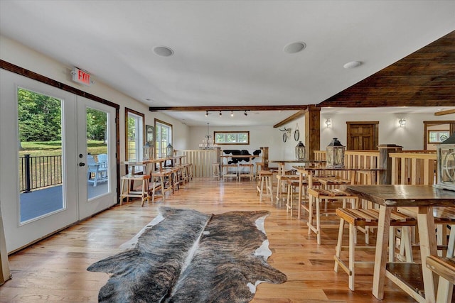 dining room with track lighting, french doors, and light wood-type flooring