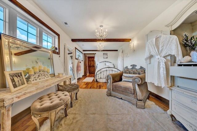 sitting room featuring baseboards, visible vents, beamed ceiling, wood finished floors, and a notable chandelier