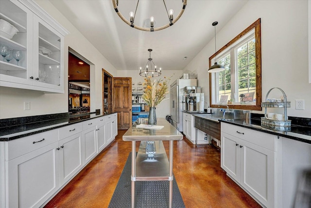 kitchen with white cabinetry, hanging light fixtures, a kitchen bar, and an inviting chandelier