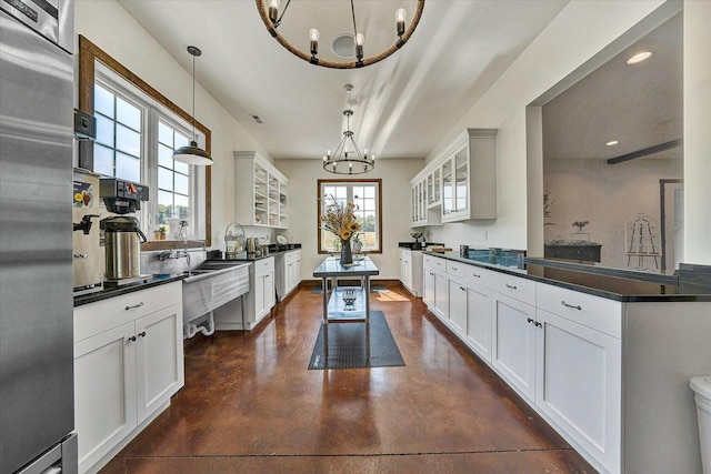 kitchen featuring high quality fridge, decorative light fixtures, white cabinetry, and a chandelier