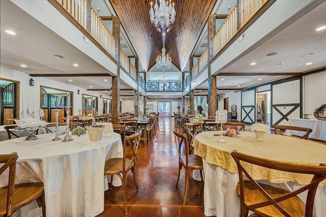 dining room featuring decorative columns, a towering ceiling, and a notable chandelier