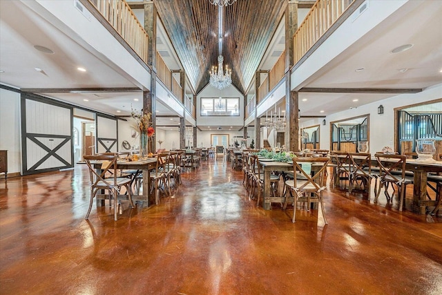 dining area featuring a notable chandelier, a high ceiling, and concrete floors