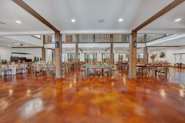 interior space featuring beam ceiling, a healthy amount of sunlight, and a towering ceiling