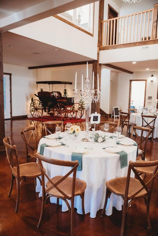 dining area with a towering ceiling, hardwood / wood-style floors, and a wealth of natural light