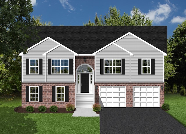 raised ranch featuring driveway, roof with shingles, a front yard, and brick siding