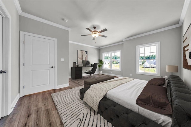 bedroom with a ceiling fan, crown molding, baseboards, and wood finished floors