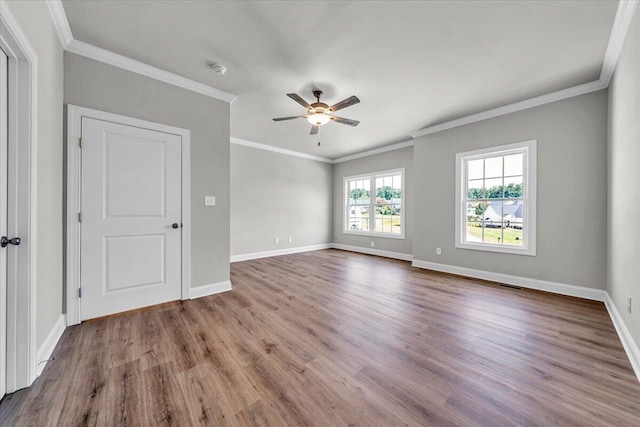 spare room featuring ceiling fan, ornamental molding, wood finished floors, and baseboards