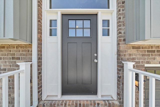 entrance to property featuring brick siding