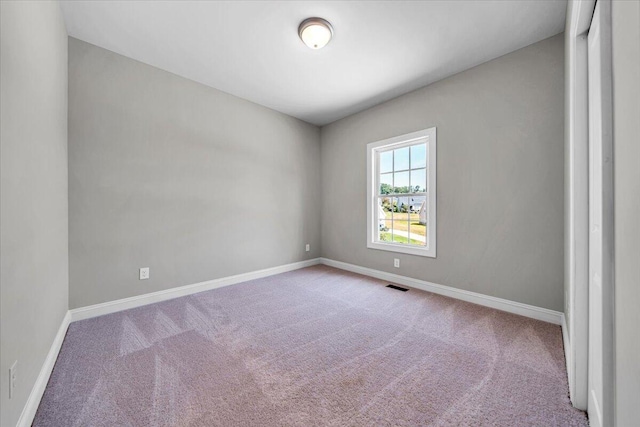 spare room with light carpet, baseboards, and visible vents