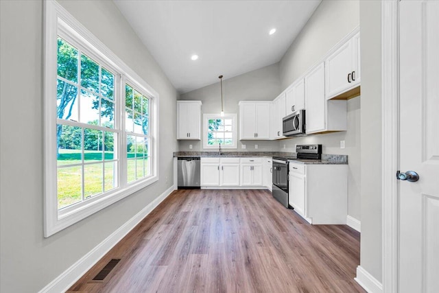 kitchen with visible vents, white cabinets, dark countertops, appliances with stainless steel finishes, and decorative light fixtures