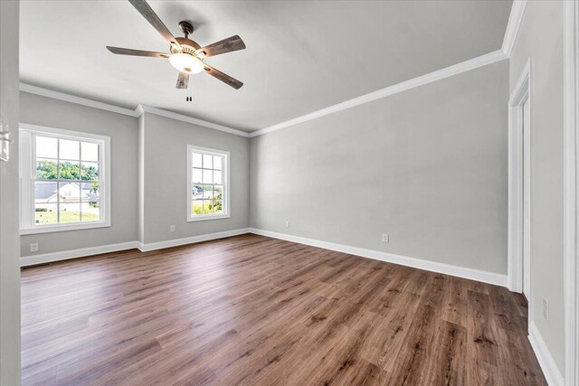 empty room featuring ceiling fan, crown molding, wood finished floors, and baseboards