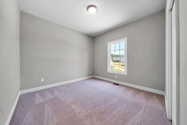 unfurnished bedroom featuring baseboards, a closet, and light colored carpet