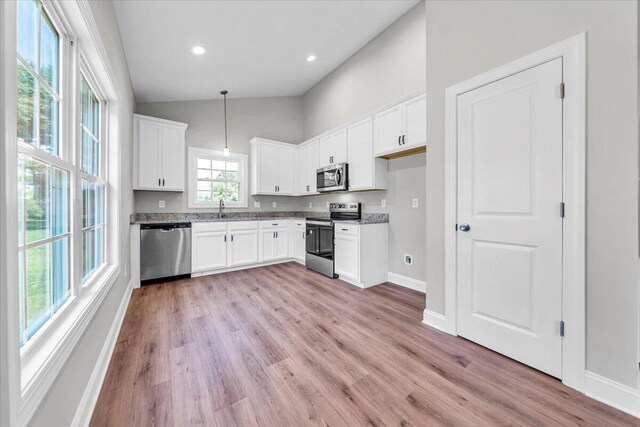 kitchen featuring visible vents, white cabinets, dark countertops, hanging light fixtures, and stainless steel appliances