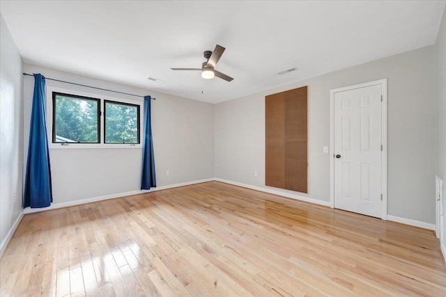 unfurnished room featuring light wood finished floors, visible vents, baseboards, and ceiling fan