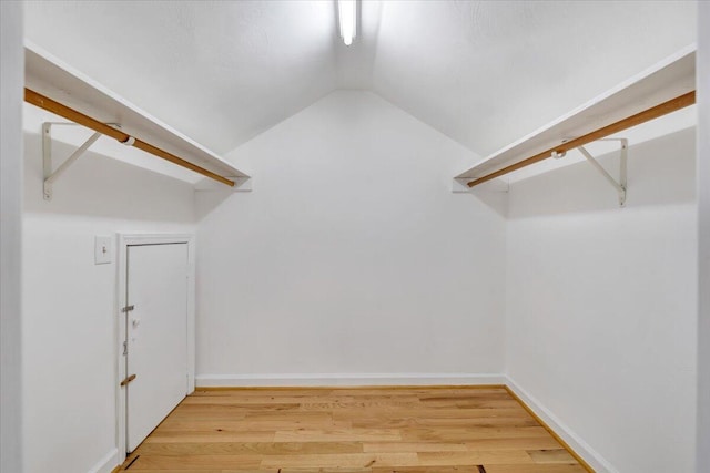 spacious closet with lofted ceiling and wood finished floors