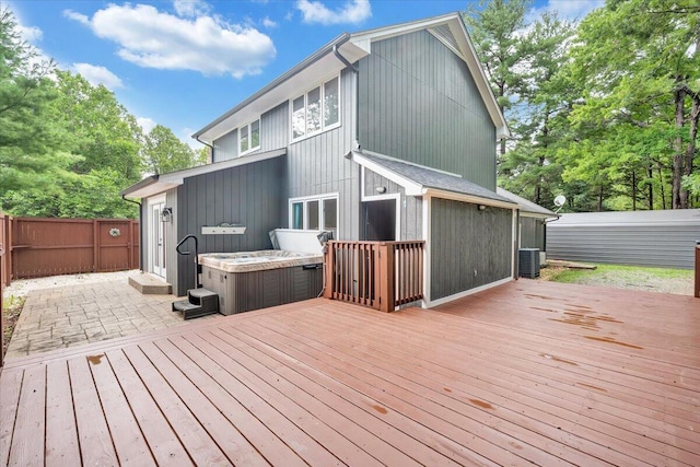 wooden terrace with fence, cooling unit, and a hot tub